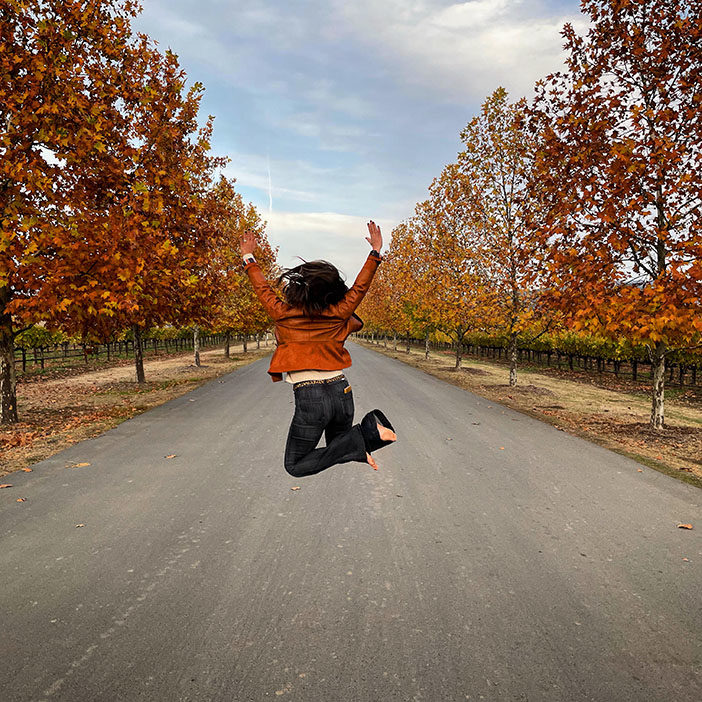 Chef Katherine jumping in the middle of a road in Napa in the fall